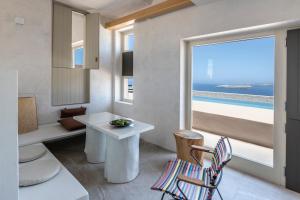 阿克罗蒂里Serra Exclusive Suites的客房设有桌子、椅子和窗户。