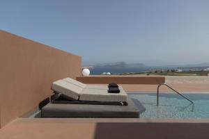 阿克罗蒂里Serra Exclusive Suites的房屋一侧带躺椅的游泳池