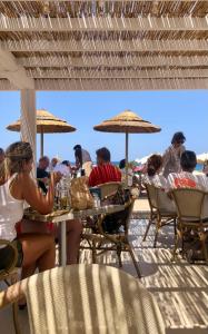 康培斯Appartamenti vicini al mare a Giglio campese的一群坐在海滩桌子上的人