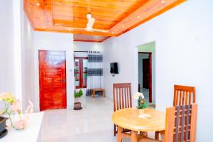 贾夫纳Thisha Hotel的一间设有桌子和红色门的用餐室
