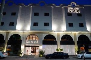 阿可贺巴Kara Hotel فندق كارا的前面有停车位的建筑