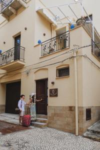 夏卡La Bifora e il granaio的两名妇女站在一座建筑物外,带行李