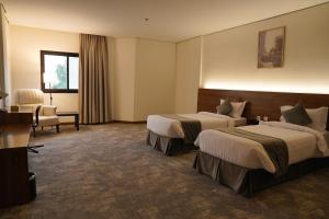阿可贺巴Kara Hotel فندق كارا的酒店客房,配有两张床和椅子