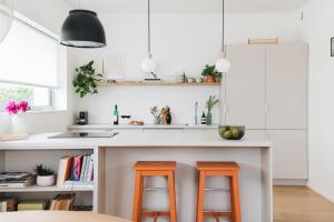 利托米什尔Apartments Marinka Litomyšl的厨房在柜台上摆放着两个橙色凳子