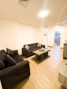 Umm Uthainahcentral apartment for rent 29的客厅配有两张沙发和一张咖啡桌