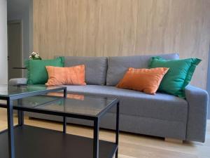 瓦伦西亚Executive STYLE near DownTwon的一张蓝色沙发,配有绿色和橙色枕头和桌子