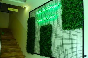 安曼Nomads Hotel的楼梯旁墙上有植物标志