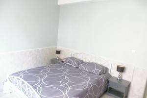 韦尔内莱班F4 VERNET LES BAINS的一间卧室配有一张带2晚台的紫色床
