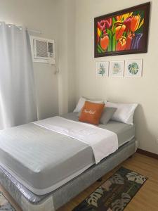 达沃市VERDON PARC CONDOMINIUM的卧室内的一张床铺,墙上有绘画作品