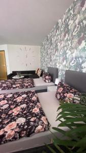 哥达RoseMarie的一间设有两张床和鲜花的墙壁的房间