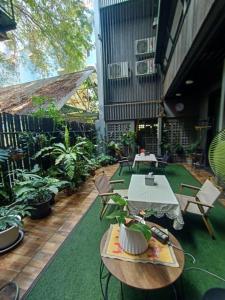 七岩Rangyen Homestay Cha-Am รังเย็น的户外庭院设有桌椅和植物