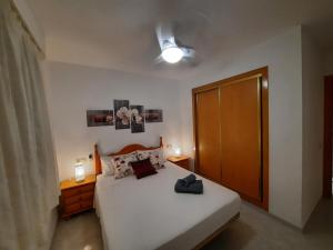 阿尔考斯布里Alcossebre RESIDENCIAL ALANDALUS 5002的卧室配有白色的床和木门