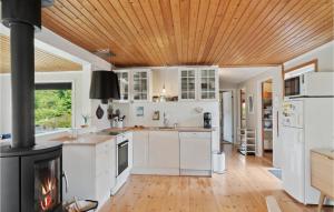 JægersprisStunning Home In Jgerspris With Kitchen的厨房配有白色橱柜和木天花板。