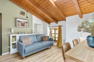 莱维科特尔梅Highlands di TSS' - Esclusivo Appartamento - Appena Rinnovato - Ottimo per Famiglie a Levico Terme的客厅配有蓝色的沙发和桌子