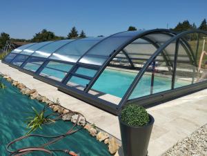 勒布朗Villa du Cerf Thibault的中间设有游泳池的玻璃建筑