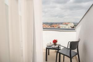 伊斯坦布尔Elm Suite Hotel的阳台配有桌子和椅子,设有窗户