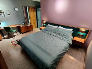 戈里察Piro's Cozy Rooms - City Centre的一间卧室配有一张大床和一张带椅子的桌子