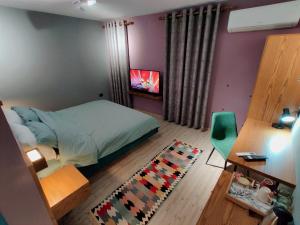 戈里察Piro's Cozy Rooms - City Centre的一间卧室配有一张床、一张桌子和一台电视