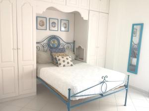 卡帕里卡海岸Caparica Lounge & Terrace的白色卧室配有蓝色框架的床