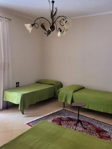 迪亚曼特Casa Murales的一间设有两张绿色床和吊灯的客房