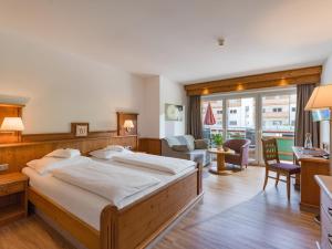 涅德劳Hotel & Alpin Lodge Der Wastlhof的一间带大床的卧室和一间客厅