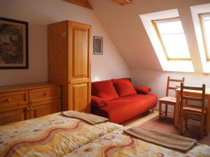 利普托斯基米库拉斯Privat Alenka的阁楼间设有一张床和一张红色沙发
