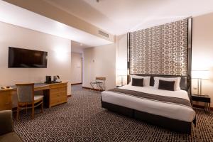 里斯本世界酒店的酒店客房设有一张大床和一张书桌。