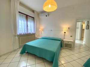 圣温琴佐Appartamento il Leccio的一间卧室设有蓝色的床和窗户。