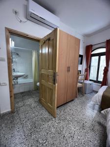 耶路撒冷William's Guest House的客房内的浴室设有大型木制橱柜