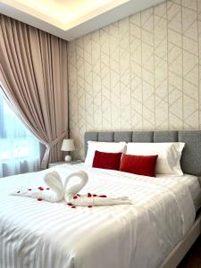 淡文Hotspring 2Room Oasis Suit @ Sunway Onsen with Theme Park View(5pax)的白色的床和红色和白色的枕头