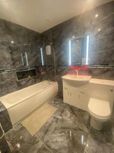 布莱克浦Jackson Holiday Apartments的带浴缸、卫生间和盥洗盆的浴室
