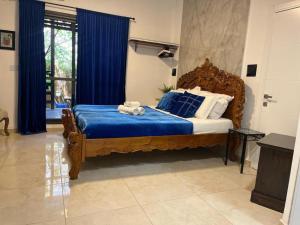 哈德拉Ahuzat Shaul Hotel Seaside的一间卧室配有一张大木床和蓝色床单