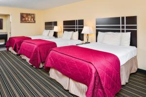 朗克斯Soudersburg Inn & Suites Lancaster的配有粉红色毯子的酒店客房的两张床