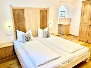 奥蒂塞伊Chalet Bernardi Apartments的一间卧室配有一张带白色床单的大床