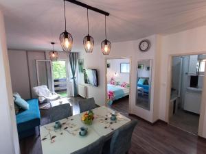 普利特维采湖Emerald Luxury Apartments的一间带桌子的客厅和一间带床的房间
