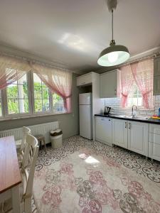 特拉布宗COUNTRY HOME的厨房配有白色橱柜和桌椅
