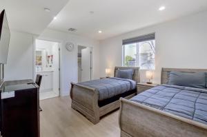 洛杉矶Modern Apartment in Studio City的一间卧室设有两张床和窗户。
