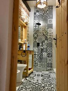 德尔米Rahoni Park & Suites的浴室铺有黑色和白色瓷砖地板,设有淋浴。