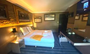 斯帕Luxury Spa Hotel - Ardennes的酒店客房设有一张大床和一张书桌。
