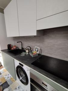 都灵SKY LOFT Nuovissimo vicinanze Metro的厨房配有水槽和洗衣机