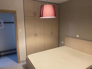 EleftheroúpolisVoulas suites的一间卧室配有一张床和一盏红灯
