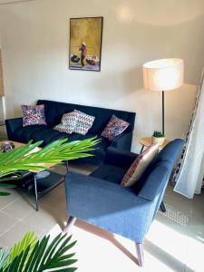 达喀尔Appartement: Dakar-Plateau的客厅配有蓝色的沙发和桌子