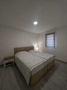 维索科Apartmani Zeleni Vrtovi的一间卧室设有一张大床和一个窗户。
