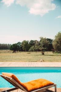 圣茹尔德马朗讷Le Ranch Kabahina Golf的坐在游泳池顶的橙色沙发