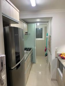 卡内拉Apartamento Gramado/Canela的厨房配有不锈钢冰箱和台面