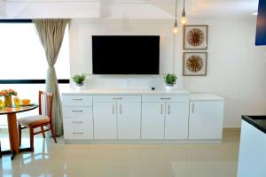 马瑙斯Tropical Executive 1305 with VIEW的一间客厅,客厅的白色橱柜上配有电视