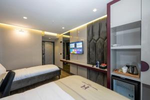 ArnavutköyHeaven Premium Hotel İstanbul Airport的酒店客房设有两张床和一台平面电视。