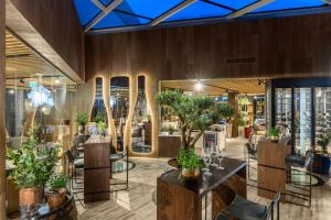 巴拉顿菲赖德Hotel Vinifera Wine & Spa 5 Stars Superior的一间设有桌椅的餐厅,种植了植物