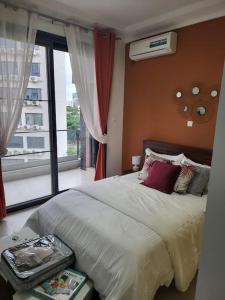 达喀尔Dakar Dreams Spinelle的一间卧室设有一张大床和一个窗户。