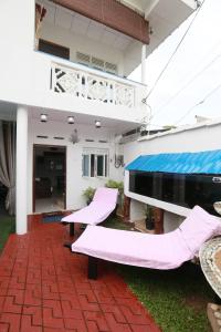 本托塔Luxury My Villa Bentota 200m Bentota Beach的一座房子的庭院,上面有粉红色的枕头